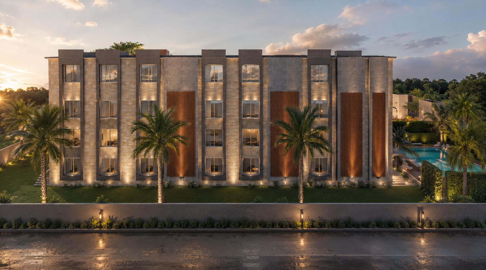 The three-storey guest room block lit at sunset, palms along the lawn in front